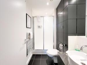 La salle de bains est pourvue de toilettes, de 2 lavabos et d'une fenêtre. dans l'établissement Lovely 2 Bed Duplex Apartment with Hydro Views, à Glasgow