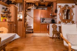 a kitchen with wooden cabinets and a table and a chair at SciliarGuestHouse-due piani parcheggio privato in Castelrotto