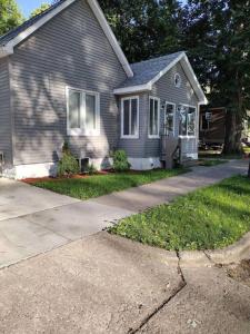 a gray house with a driveway in front of it at Modern home on city's westside in Bay City