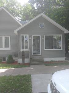 a gray house with a parking meter in front of it at Modern home on city's westside in Bay City