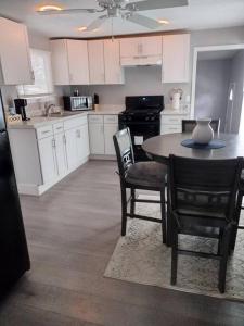 a kitchen with white cabinets and a table and chairs at Modern home on city's westside in Bay City