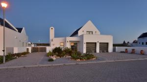 a large white house with a street light in front of it at Strandkiewiet in Jacobs Bay