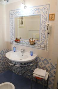 bagno con lavandino e specchio di B&B La Vetreria Almarù a Catania