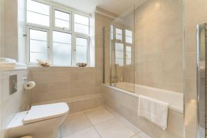 La salle de bains est pourvue de toilettes, d'une douche et d'une baignoire. dans l'établissement Spacious apartment in the heart of Brighton, à Brighton et Hove