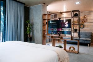1 dormitorio con 1 cama, TV y sofá en Living by Armoniko, en Medellín