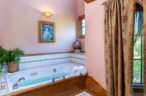 a bath tub in a bathroom with a window at Angel at Rose Hall in Eureka Springs