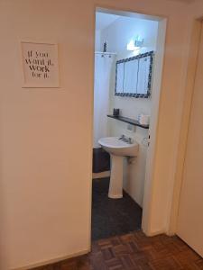a bathroom with a sink and a sign on the wall at Obelisco in Buenos Aires