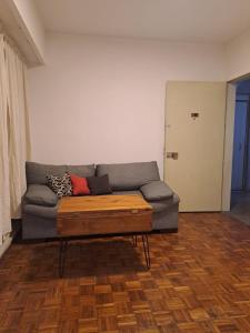 sala de estar con sofá y mesa de centro de madera en Obelisco en Buenos Aires