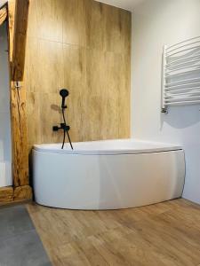 a white bath tub in a room with a camera at Apartamenty Happy & Relax in Bielsko-Biała