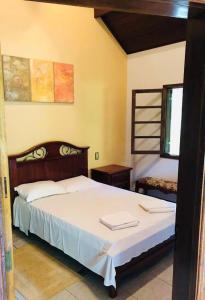 - une chambre avec un grand lit et des draps blancs dans l'établissement Pousada 1800 Altitude Monte Verde, à Monte Verde