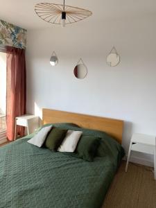 una camera da letto con un letto con un piumone verde di L'appart Fréjus plage a Fréjus