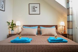 Un dormitorio con una cama con almohadas azules. en Airport Glossel Panzió, en Vecsés