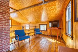 um quarto com duas cadeiras, uma mesa e uma televisão em Catskills Cottage with Deck, 7 Mi to Hunter Mtn em Elka Park