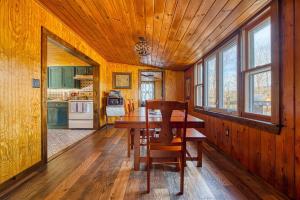 uma cozinha com uma mesa de madeira e cadeiras num quarto em Catskills Cottage with Deck, 7 Mi to Hunter Mtn em Elka Park