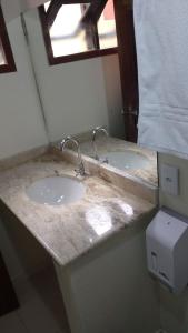 2 lavabos en un baño con encimera de mármol en Pousada Hannah en Prado