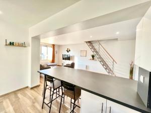 een keuken en een woonkamer met een aanrecht en een trap bij La havane, paisible gîte à 5 min du Futuroscope in Saint-Georges-lès-Baillargeaux