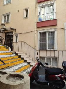 un scooter automobile garé devant un bâtiment dans l'établissement Şişli'de Merkezi Konumda ve Konforlu Aile Evi, à Istanbul