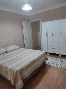 - une chambre avec un grand lit et des placards blancs dans l'établissement Şişli'de Merkezi Konumda ve Konforlu Aile Evi, à Istanbul
