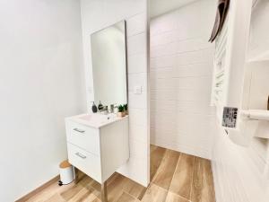 La salle de bains blanche est pourvue d'un lavabo et d'un miroir. dans l'établissement La havane, paisible gîte à 5 min du Futuroscope, à Saint-Georges-lès-Baillargeaux