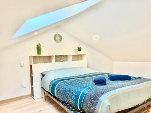 een slaapkamer met een bed op zolder bij La havane, paisible gîte à 5 min du Futuroscope in Saint-Georges-lès-Baillargeaux