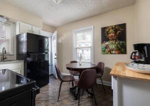 a kitchen with a table and a black refrigerator at Amazing 4BD 2BA Home In Kentucky in Louisville