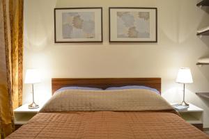 a bedroom with a bed, a lamp and a painting on the wall at Airport Glossel Panzió in Vecsés