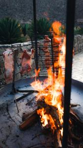 una parrilla de fuego con un poco de carne en ella en Chañarmuyo Casa de Huéspedes en 