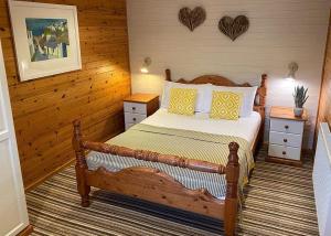 a bedroom with a bed with yellow and white pillows at Ivyleaf Combe Lodges in Stratton
