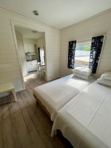 sypialnia z dużym białym łóżkiem i kuchnią w obiekcie Trolltunga Studios w mieście Odda