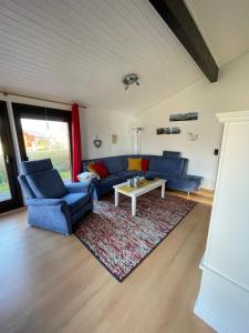 a living room with blue couches and a rug at Eckwarderhörne Objekt B 15 in Großwürden