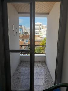 a room with a window with a view of a city at Ap 300m praia do morro in Guarapari