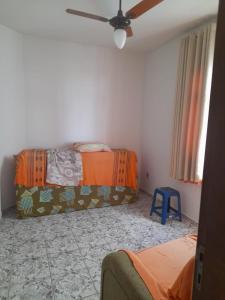 a room with two beds and a ceiling fan at Ap 300m praia do morro in Guarapari