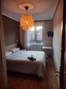 a bedroom with a bed with a hat on it at Alberto Astur Habitaciones privadas màs cocina compartida in Oviedo