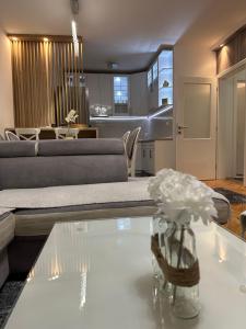 a living room with a couch and a table with flowers at Central Luxury Suites in Bijeljina +16 photos