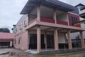 un bâtiment rose avec colonnes dans l'établissement OYO 92243 Fanilly Guest House Marabahan, à Banjarmasin