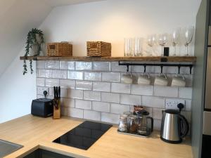 a kitchen with a counter with glasses on a wall at The Bolthole in South Hayling