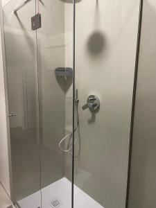 une cabine de douche avec une porte en verre dans l'établissement Number 99 - Number House, à Bergame