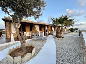 ein Resort mit Palmen und einem Gebäude in der Unterkunft Dammusi cala croce in Lampedusa
