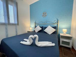 two towels shaped like swans sitting on a bed at Dammusi cala croce in Lampedusa