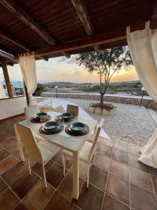 einen Tisch und Stühle auf einer Terrasse mit Aussicht in der Unterkunft Dammusi cala croce in Lampedusa