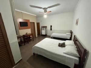 a bedroom with two beds and a ceiling fan at Hotel Portela II in Olímpia