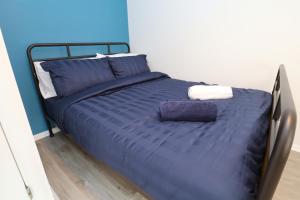 ブライトン＆ホーブにあるWindsor Lodgeのベッド(青い掛け布団、枕付)