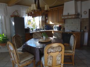 a kitchen with a table and chairs and a refrigerator at Haus Eifelinchen in Schleiden