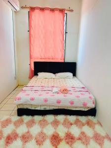 Bella Homestay Beaufort Sabah في بوفورت: غرفة نوم صغيرة مع سرير ونافذة وردية