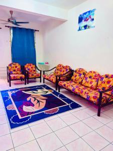 Bella Homestay Beaufort Sabah في بوفورت: غرفة معيشة بها كنبتين وسجادة