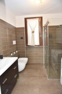 a bathroom with a toilet and a shower and a window at Design & Comfort a Romano di L. in Romano di Lombardia