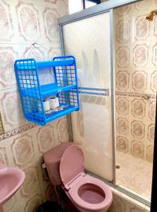 baño con aseo rosa y cesta azul en Casa nómada Puyo, en Puyo