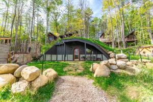 una casa con techo verde y patio en Trekker, Treehouses cabins and lodge rooms, en Lake George