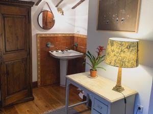 ein Badezimmer mit einem Waschbecken und einem Tisch mit einer Lampe in der Unterkunft El molino de La Infinita: Un coqueto molino con río propio in Carmona