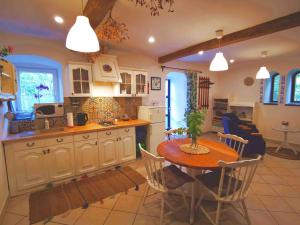 a kitchen and dining room with a table and chairs at Mazurski Ogród - dom z ogrodem, kominkiem i wiatą biesiadną in Wydminy +26 photos